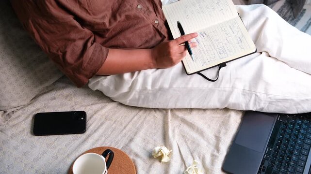 Woman working from home with laptop and journal, researching and developing creative ideas, brainstorming, remote work, ideation and planning concept