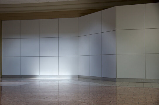 blank wall made up of squares with center lit