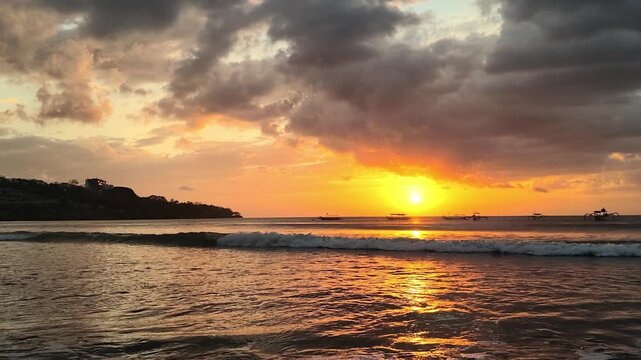 Sunset over Jimbaran Beach with waves rolling in, Bali, Indonesia