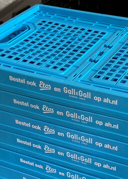 den haag, netherlands - may 13 2026: Bright blue plastic delivery crates from Albert Heijn are stacked high. They carry groceries and goods, also advertising Etos and GallGall.