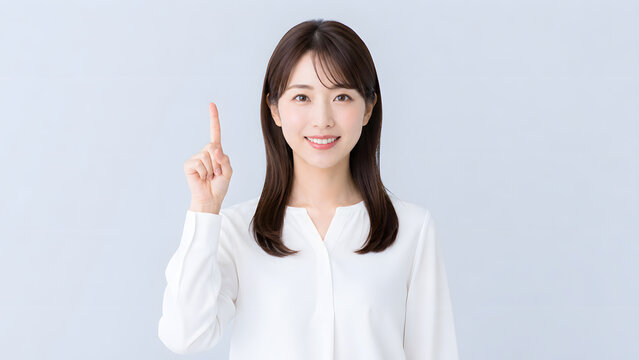 上を指差し笑顔で重要なポイントを案内する若い日本人女性