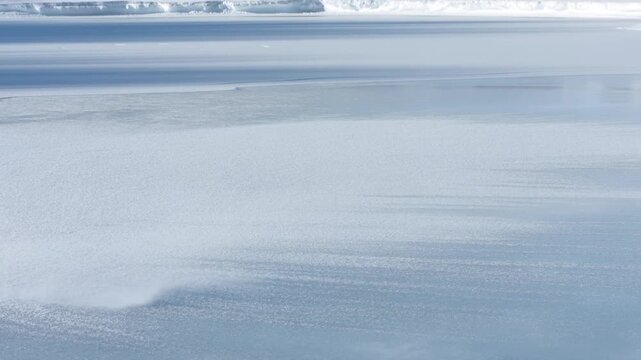 Blue ocean surface beneath cloudy sky with layered horizon and calm water texture