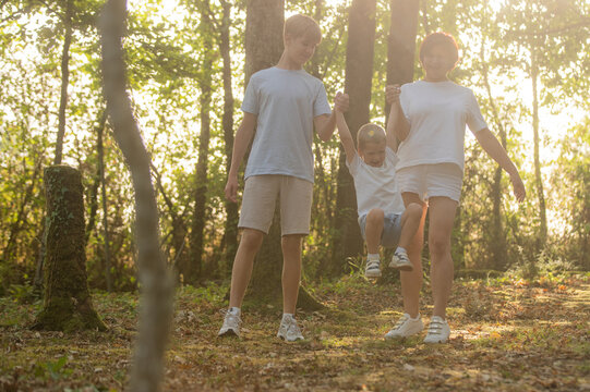 A group of cheerful people walking and having fun together in a beautiful nature setting on a sunny day, feeling the beauty and the energy of the outdoors, Happy family day 
