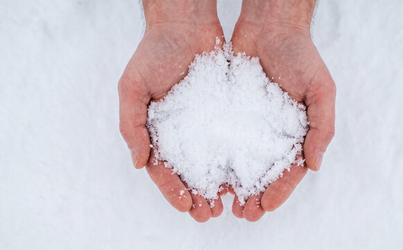 Hands holding fresh white snow winter season concept outdoor nature close up