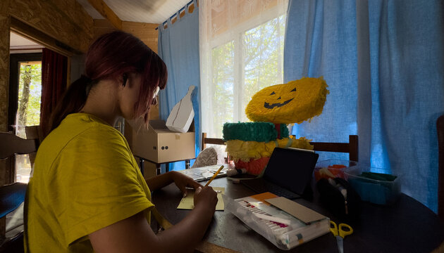 The girl is doing creative work. Traditional Mexican pinata 
