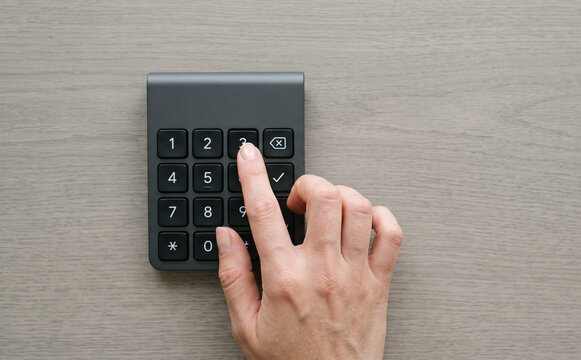 Woman hand pressing number 3 button on security keypad lock device for entry password code