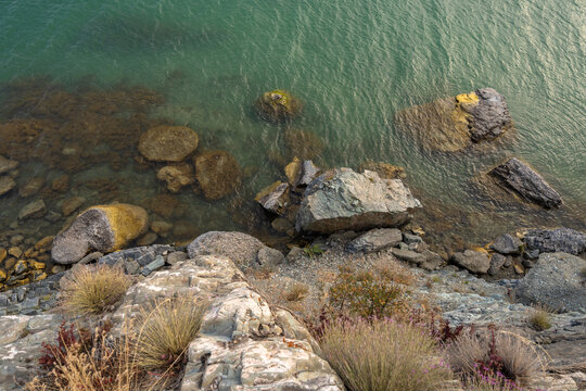 The sea is shown with clear water and a rocky shore