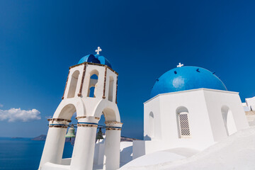 Blue domed churches and whitewashed houses in Oia Santorini Greece overlooking the Aegean Sea caldera © Vlad Ispas