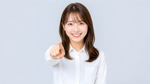 カメラに向かって笑顔で指差しする若い日本人女性