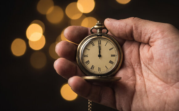 Man holding antique pocket watch showing twelve oclock time concept for waiting deadline or midnight bokeh background