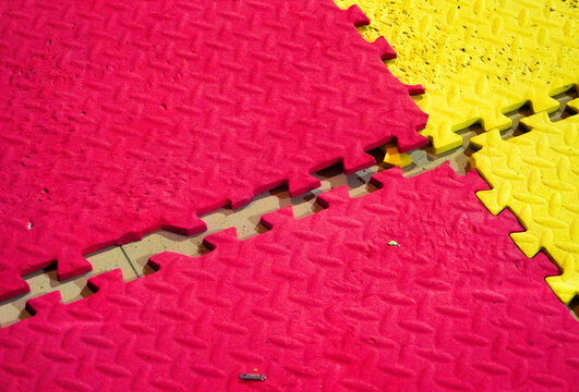 Colorful Interlocked foam Jigsaw tiles on a playmat. disconnected colour puzles. Colorful blue mat texture background. Can be used for yoga, judo or a playground for kids. Busines team work concept. 