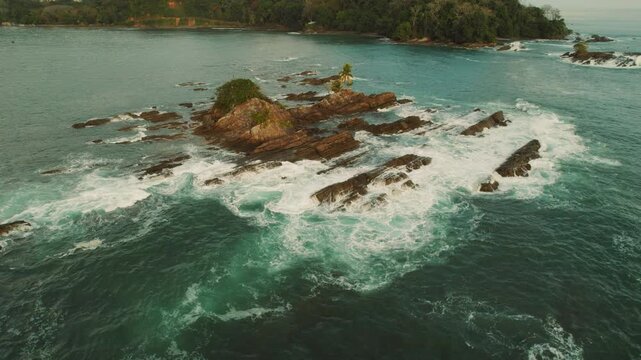Rocky islets surrounded by turquoise ocean waves near coastline in Costa Rica