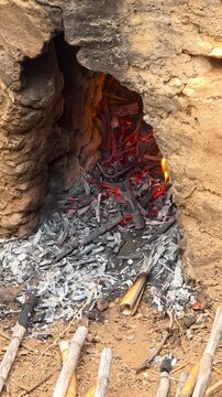 Close up of hot fire and glowing embers in stone kiln oven for traditional scalding close up