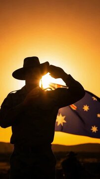 Australian soldier in silhouette saluting at sunset with national flag for Anzac Day tribute and military respect concepts