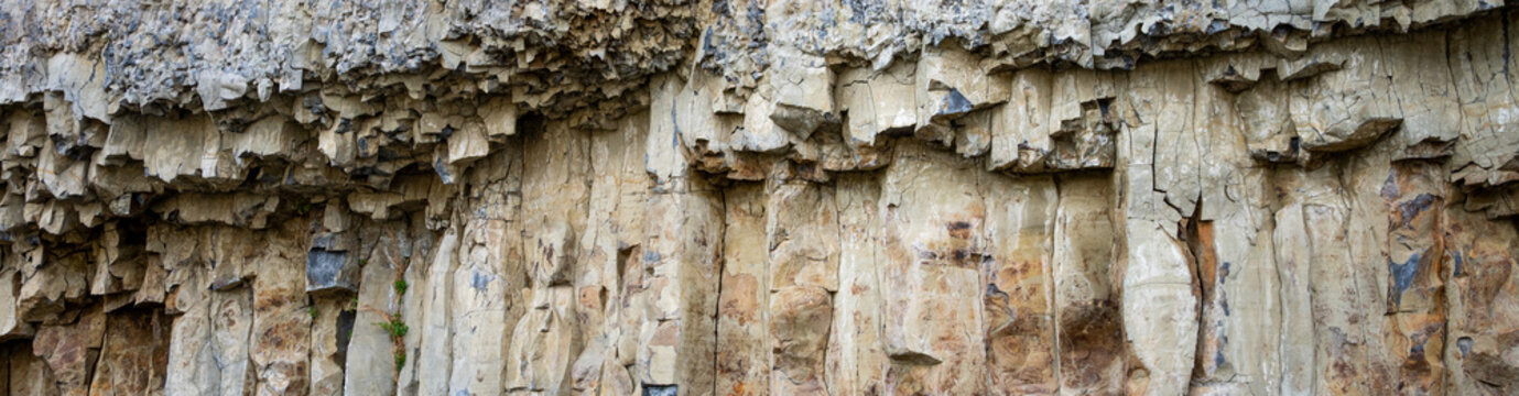 Columnar Basalt rock cliff next to road, pattern and texture nature background, Yellowstone National Park
