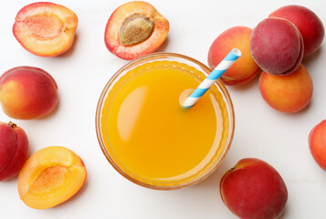 Apricot juice in glass and fresh fruits on white table, flat lay © New Africa