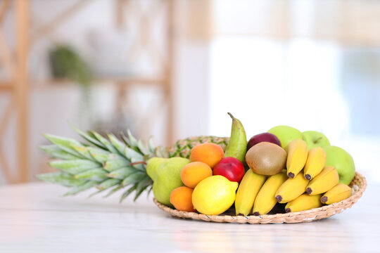 Mix of fresh juicy fruits on white marble table in kitchen