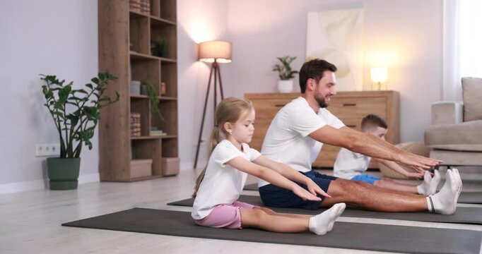 Father and his kids doing exercise together at home