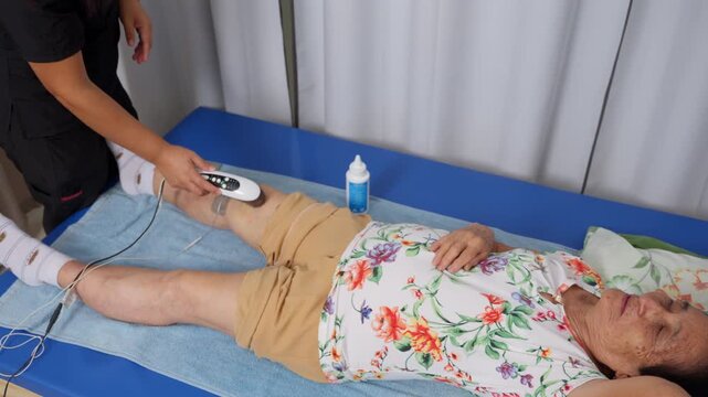 Elderly patient receiving ultrasound and electrotherapy treatment on leg