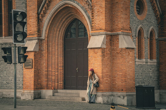 Woman leaning against brick corner near Union Church entrance, Shanghai