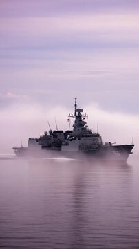 Warship in fog sailing on calm sea, military vessel in misty water, naval defense concept