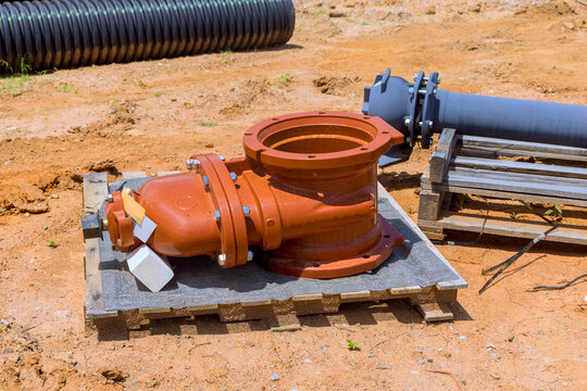 Valve is placed on pallet next to pipes during work at construction site