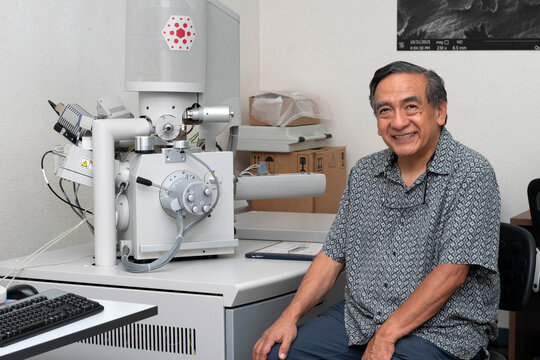 Smiling Senior Scientist Beside Scanning Electron Microscope in Laboratory