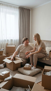 Couple unpacking cardboard boxes at home