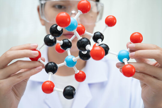 Scientist holding molecular model for chemical technology.