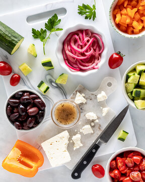Above view of various fresh ingredients used for making a mediterranean salad.