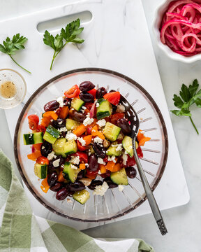 Above view of a glass bowl filled with a homemade mediterranean salad.