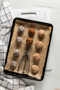 A parchment paper lined baking sheet topped with various homemade energy balls.