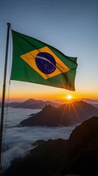 Brazilian flag waving over majestic mountain peaks at sunrise with sea of clouds for patriotism and travel concepts