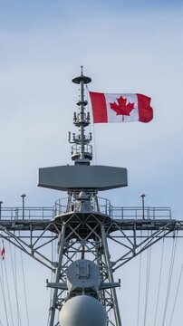 Canadian naval ship mast with flying flag on clear sky background for military and defense concepts