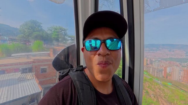 Young man riding medellin metrocable cable car