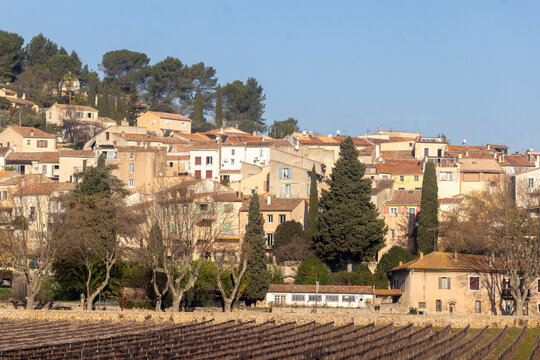 Provence, France &ndash; December 31, 2025: A charming hillside village with warm terracotta roofs overlooks dormant winter vineyards in Mediterranean France.