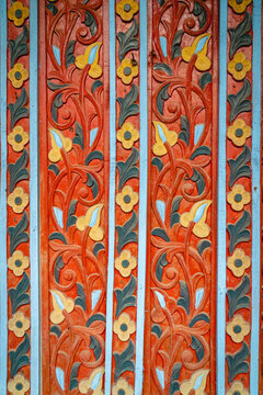 Traditional Minangkabau wood carving featuring intricate floral motifs, curling vines, and colorful ornamental patterns inspired by Indonesian cultural heritage.