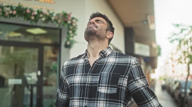 Man tilts head back exposing neck and closing eyes while standing on a street in front of a storefront window; relief release.