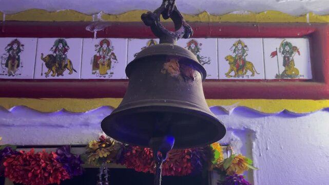 Traditional Hindu Temple Bell with Colorful Religious Artwork in India

