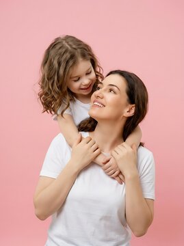 Cheerful mother and daughter embracing and looking at each other