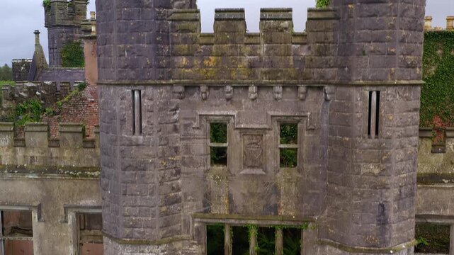 Descending aerial scanning towers with cross-shaped arrow loops revealing mullioned windows and stone masonry, Cavan Ireland
