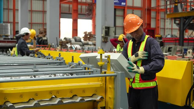 Engineers and staff are inspecting the assembly line system in a metal sheet and metal roofing manufacturing plant. (VDO 4K)	