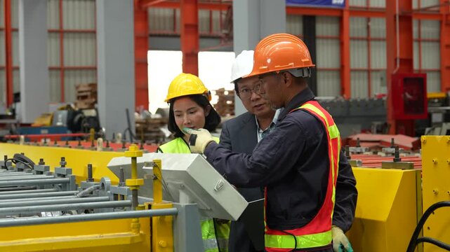 Engineers and staff are inspecting the assembly line system in a metal sheet and metal roofing manufacturing plant. (VDO 4K)	