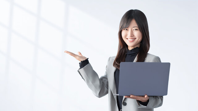 パソコンを持って案内する女性・ビジネスウーマン, Businesswoman Presenting a Laptop