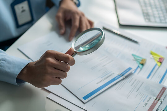 Close-up of magnifying glass focusing on words of resume document for recruitment concept.