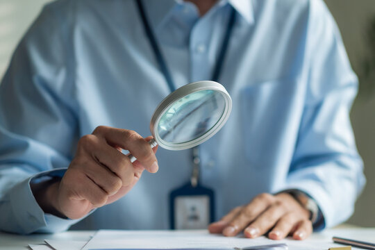 Close-up of magnifying glass focusing on words of resume document for recruitment concept.