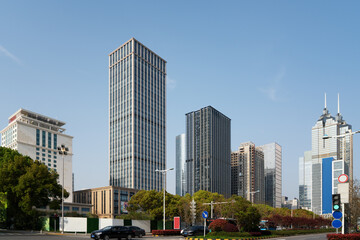 Obraz premium Modern urban skyline with multiple tall buildings under clear blue sky