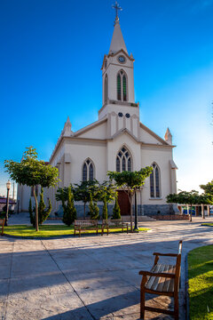 St. Sebastian Matriz Church with a modern water fountain reflection in the foreground. Beautiful white historic neogothic architecture located in a sunny public square 