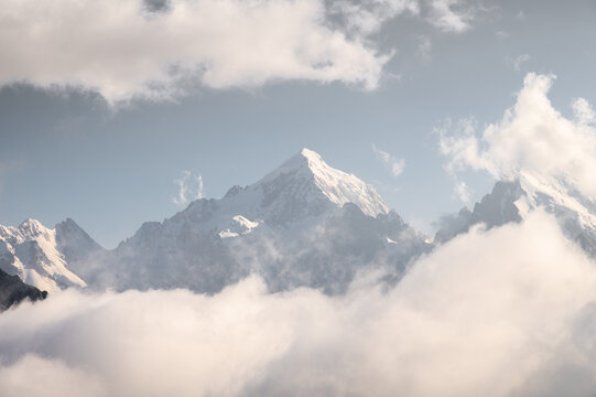 Snow Capped Mountain Peak Rising Above Clouds
