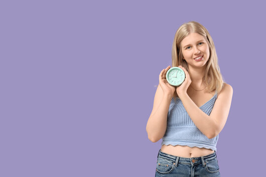 Time management and deadline pressure, young woman holding a clock to represent punctuality and schedule planning on a solid purple background